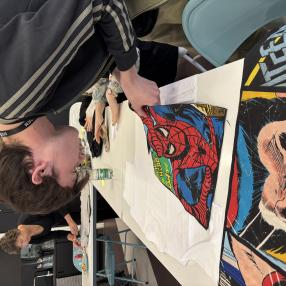 A young person creating a superhero shirt from upcycled materials