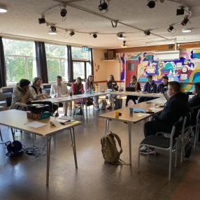 The first workshop, in Pie Factory Music, Ramsgate. The speakers and participants are sitting at a table, discussing. 